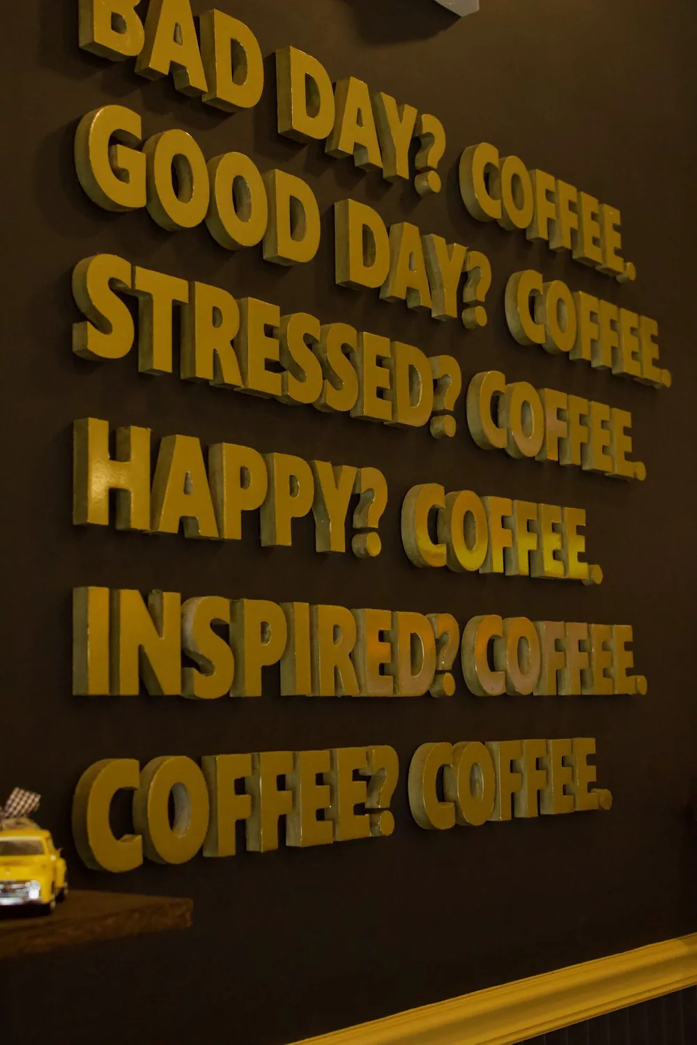 The café's gold-lettered wall: Bad day? Coffee. Good day? Coffee.