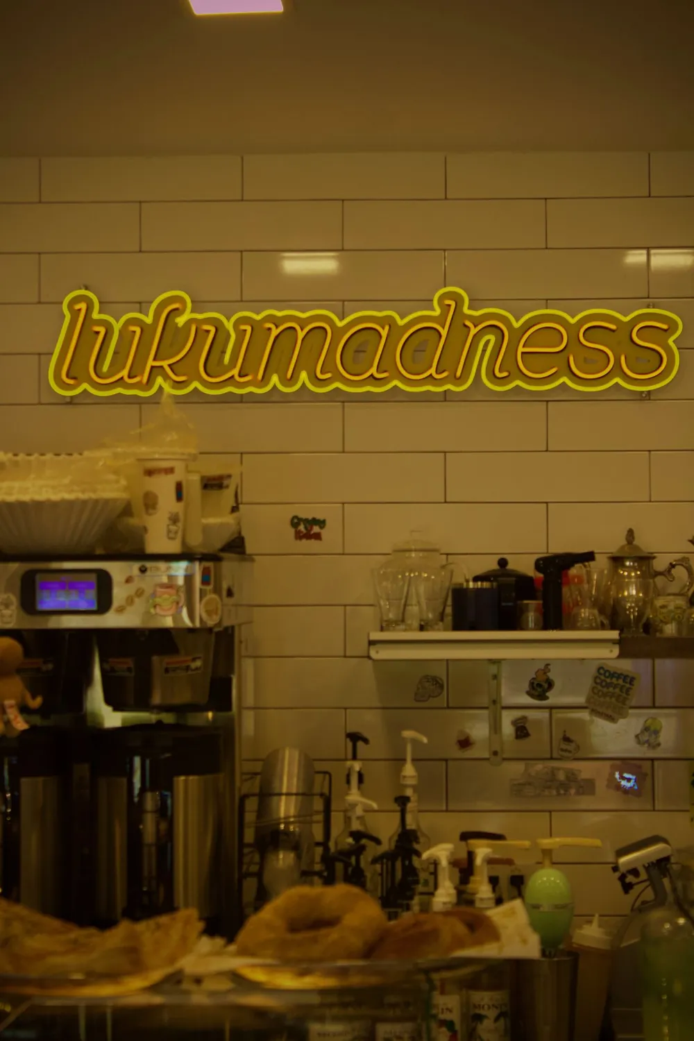 The glowing LukuMadness neon sign above the espresso bar